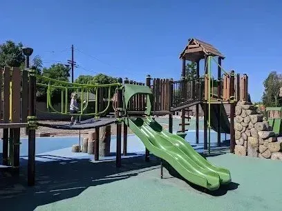 Window Tinting Service-A green slide is sitting in the middle of a playground.