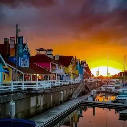 Window Tinting Service-A sunset over a marina with colorful buildings and boats