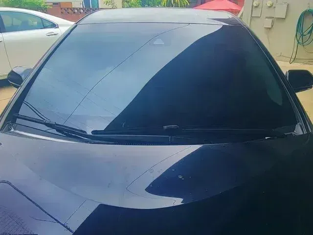 Window Tinting Service - A picture of the front side of a cars windshield with window tint film installed