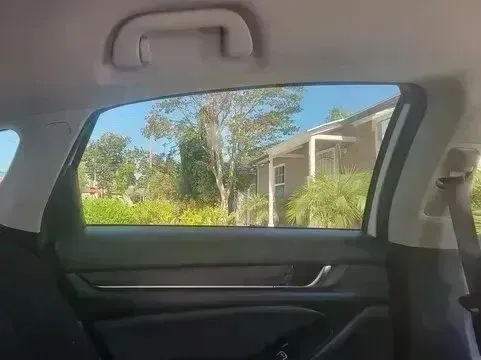 Window Tinting Service - picture of a car window looking outside with tint installed