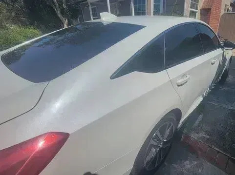 Window Tinting Service - A picture of the backside of a white car with window tint installed