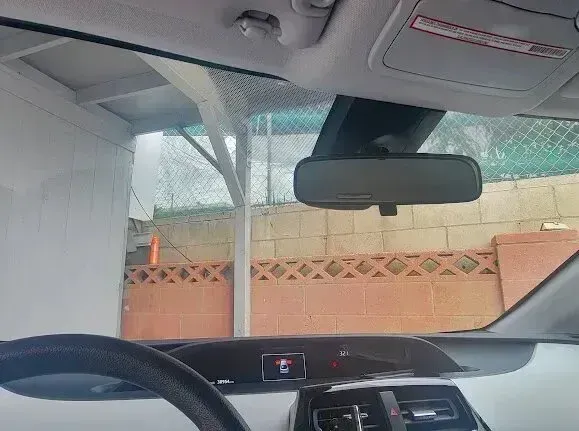 Window Tinting Service - A picture of a windshield looking outside a garage with window tint film installed