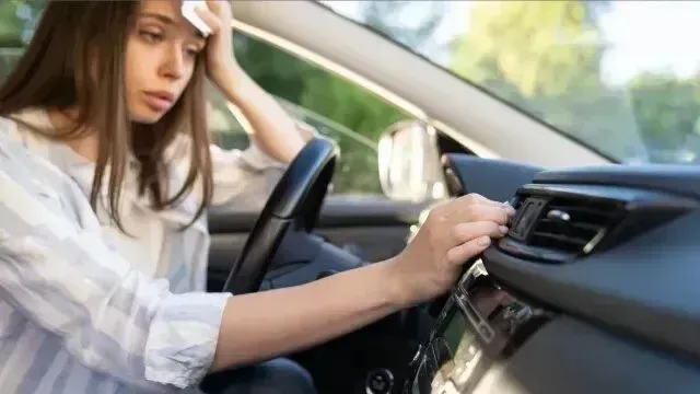 Window Tinting Service - a woman in a car wipes her face with a napkin