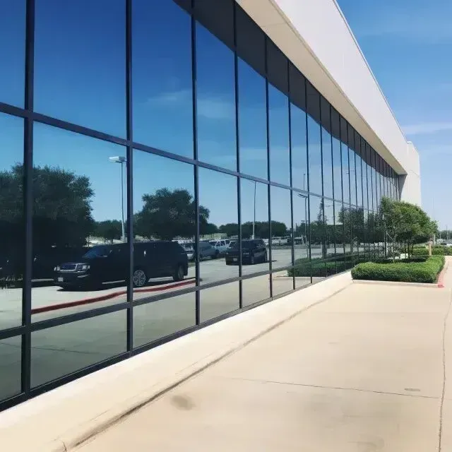 Window Tinting Service - a black suv is parked in front of a building with a lot of windows