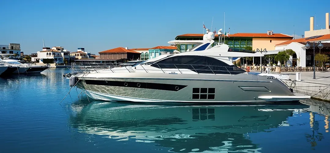 A large yacht is docked in a marina next to a building.