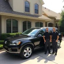 two men standing in front of a black volkswagen