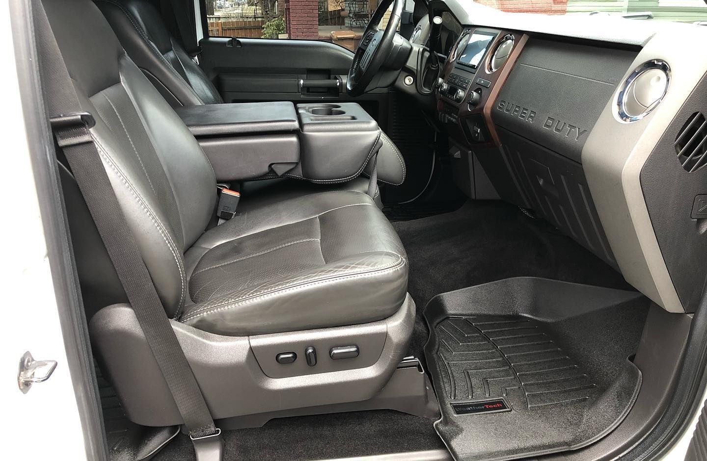 The interior of a white truck with black leather seats.