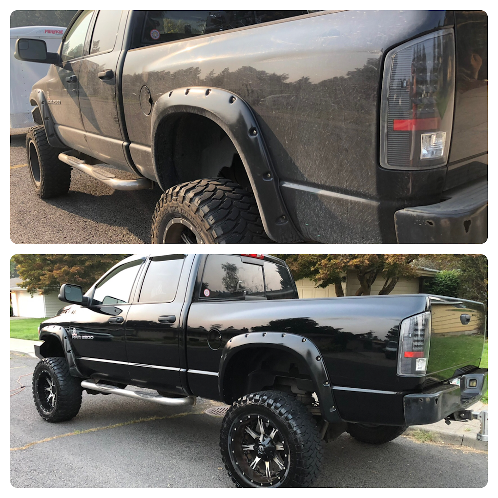 A black truck is parked on the side of the road