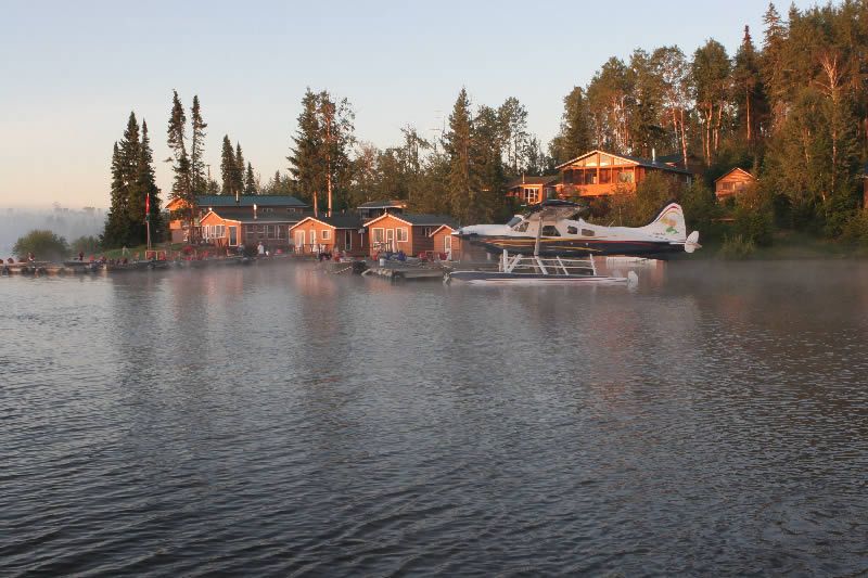 A seaplane is sitting in the water near a dock.