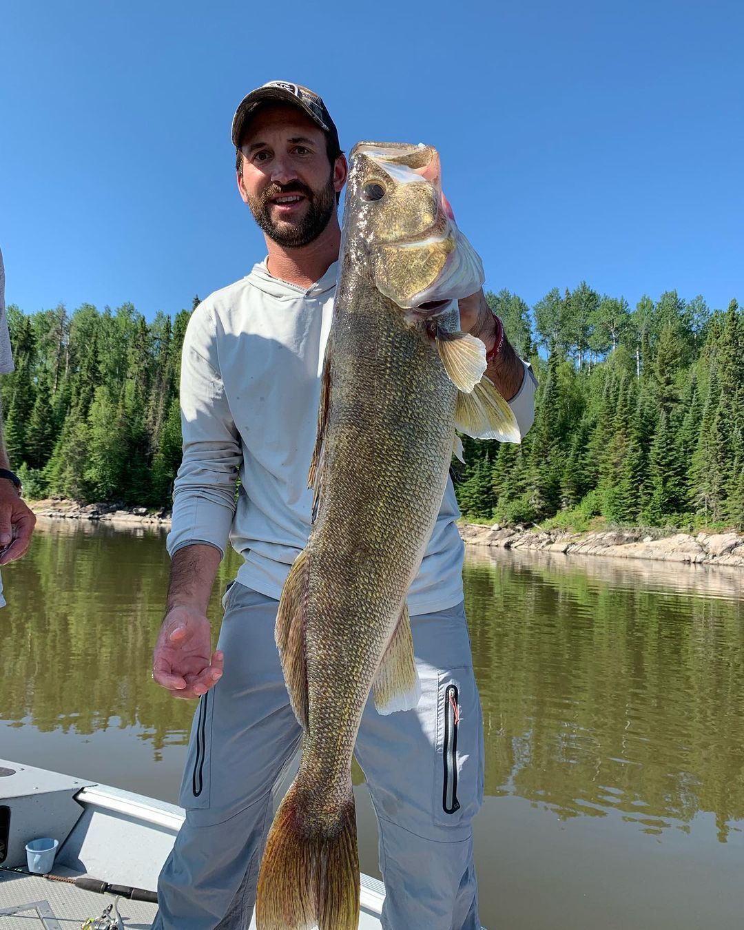 A happy fisherman holding a large walleye fish caught at Oak Lake Lodge fly-in fishing lodge in Ontario, Canada.