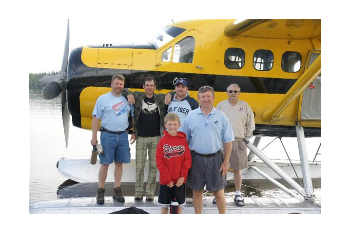 A family standing beside a float plane during a fly-in fishing vacation to Canada.
