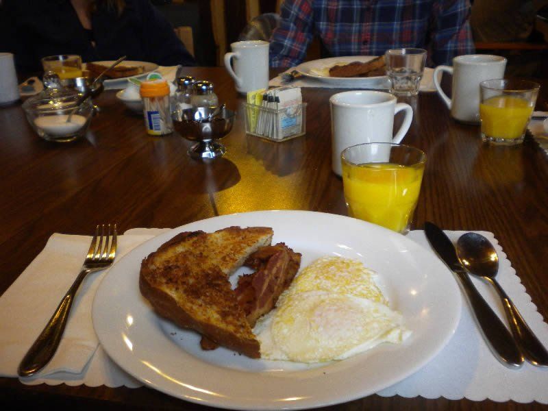 A plate of food with eggs bacon and toast on a table
