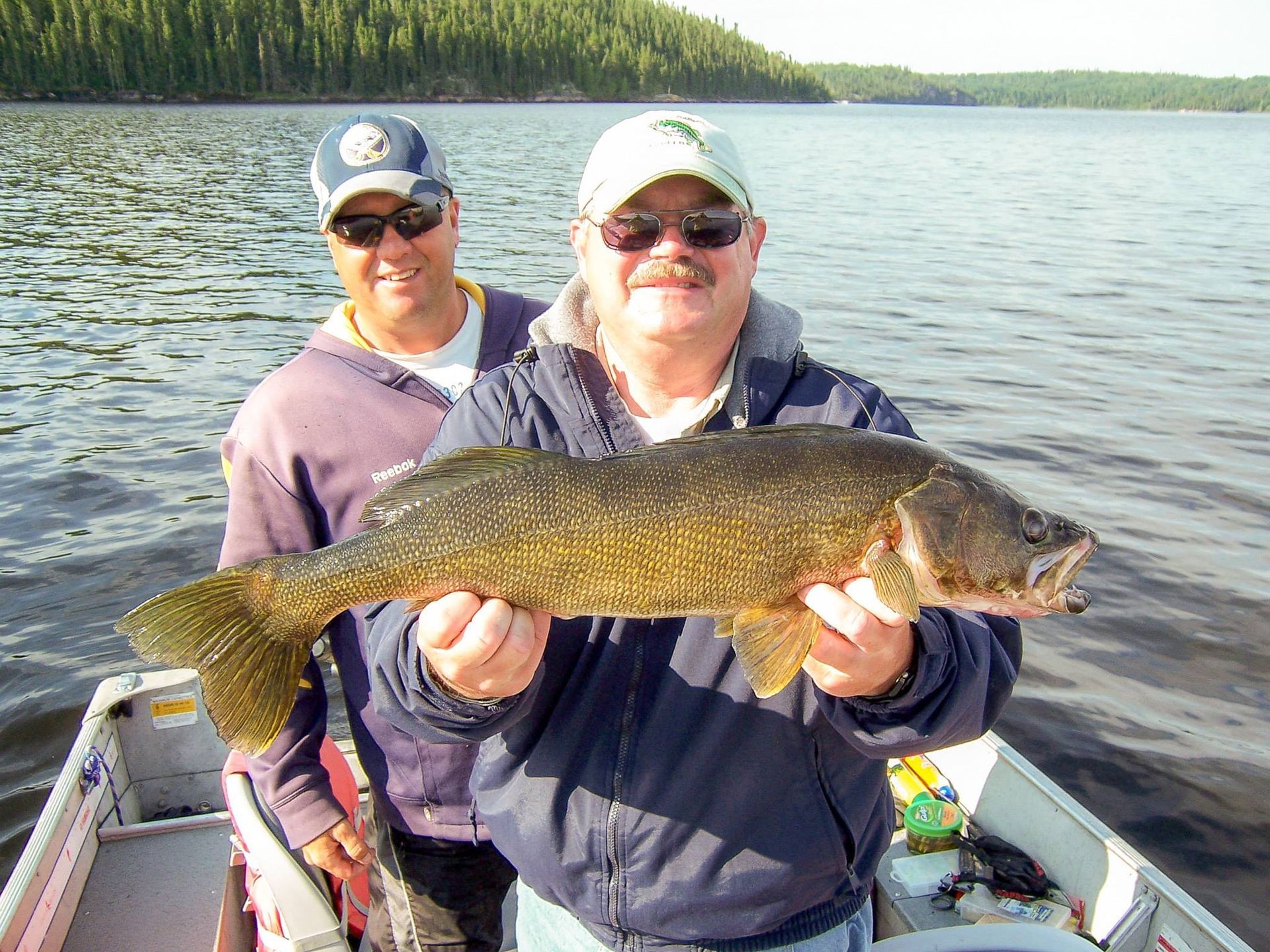 Two recreational fishermen at Oak Lake Lodge holding up a walleye.