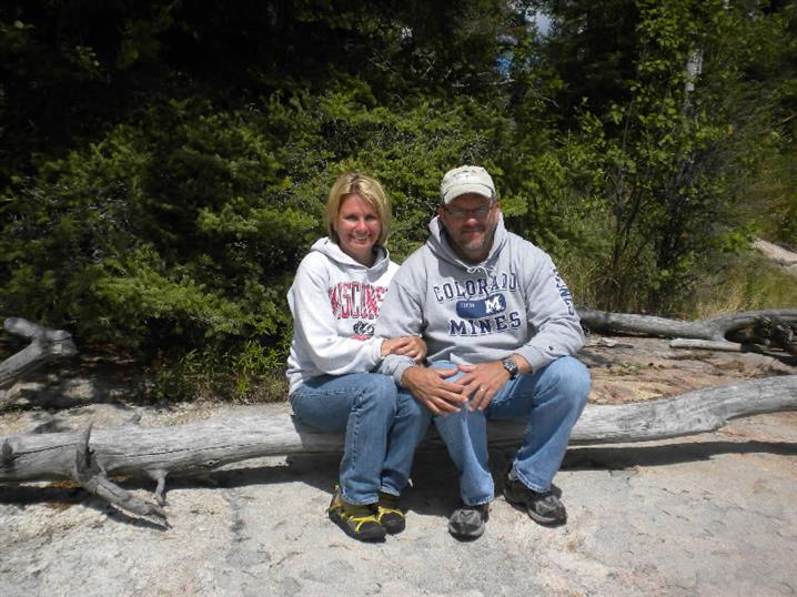 A couple sitting on a log on the shores of Oak Lake.