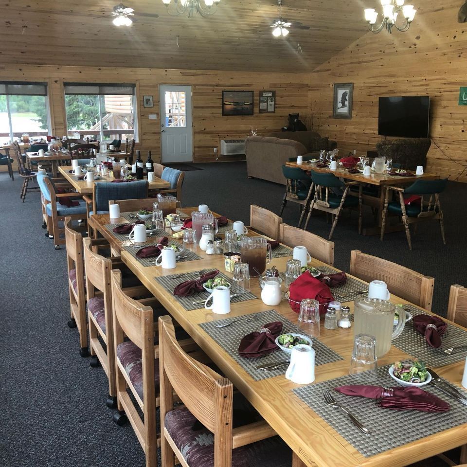 A dining room with tables and chairs set up for a meal