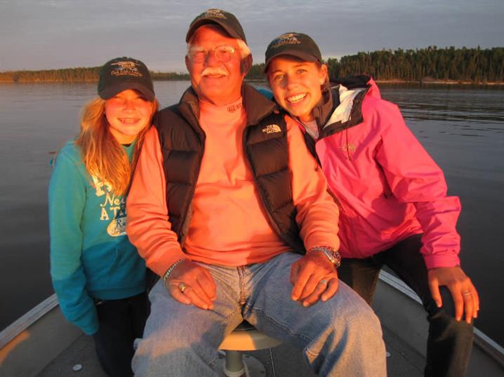 A family sitting in a fishing boat at Oak Lake Lodge.