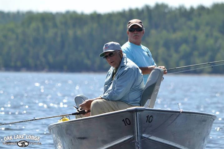 Two fishermen in a boat on a sunny day fishing in Canada.