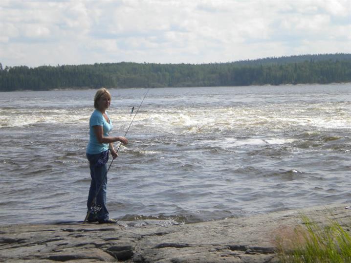 Woman fishing on the Canadian Shield at Oak Lake Lodge.