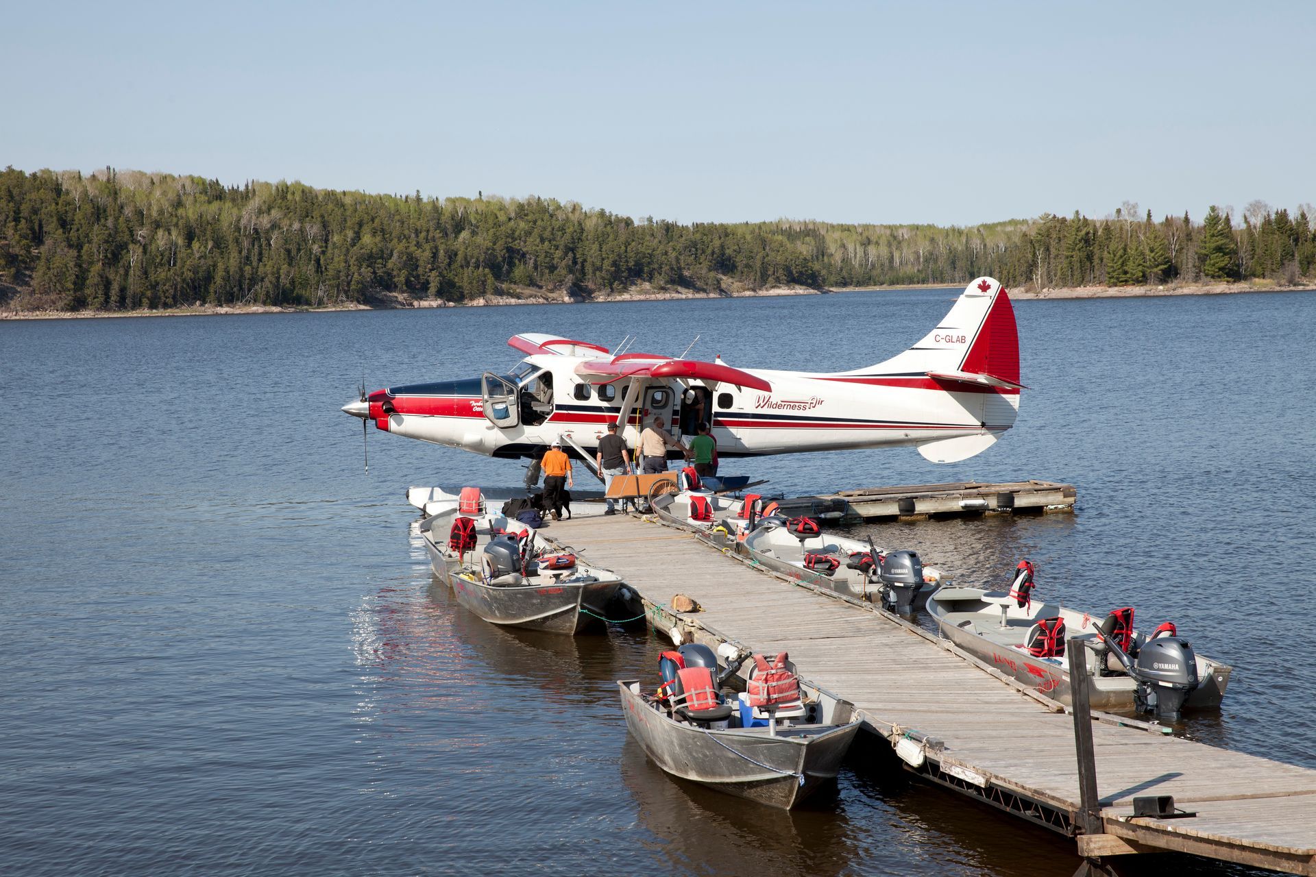 A red and white plane is docked at a dock