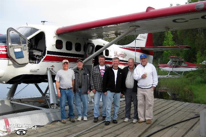 group of fishermen standing in front of a Wilderness air float plane.