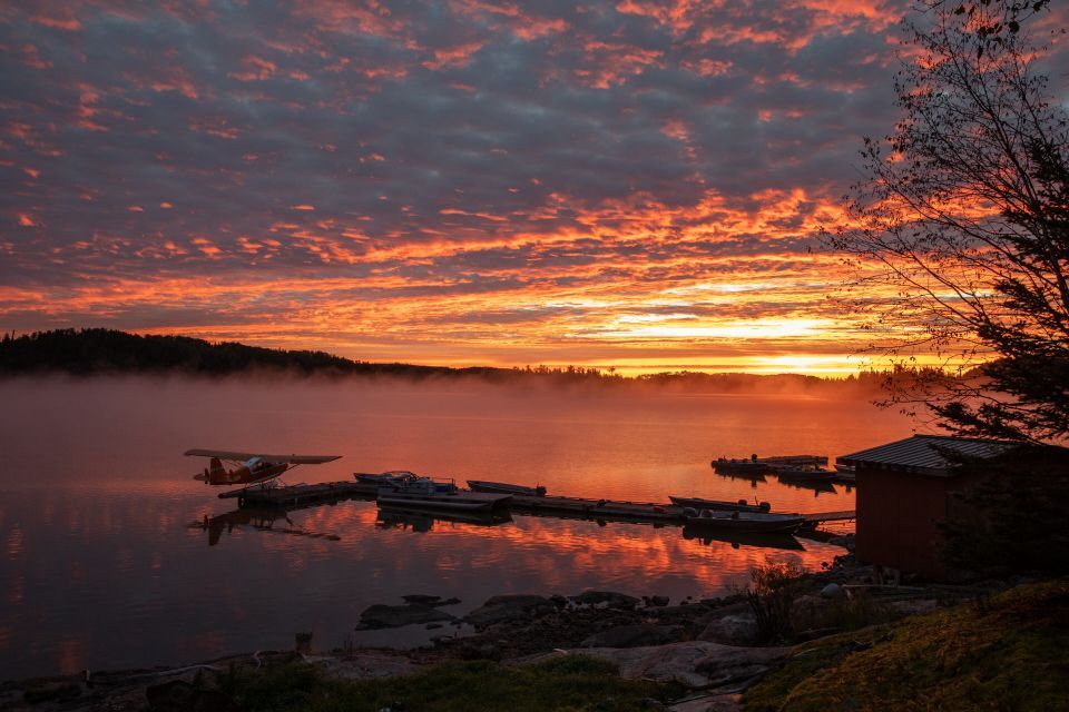 A sunset over a lake with boats docked in the water.