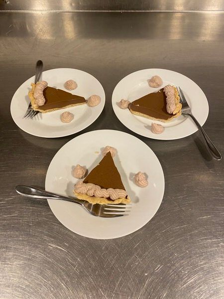 Three plates with slices of pumpkin pie on them
