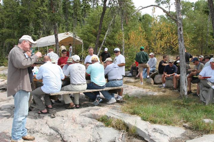 A group of fishermen enjoying a  fish fry of walleye for a shore lunch at Oak Lake Lodge.