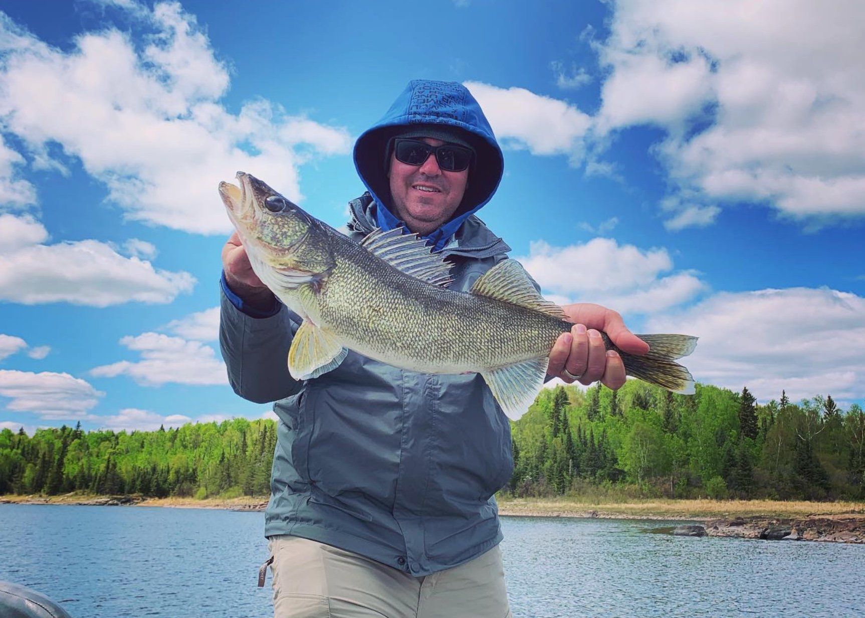 Fisherman holding a walleye on a fly-in fishing trip to Canada.