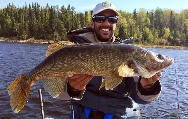 David holding up a very large walleye on a sunny day.