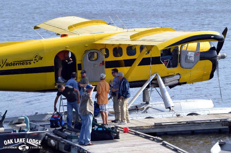A yellow float plane docked at Oak Lake Lodge.