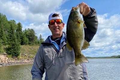 Zeke holding up a smallmouth bass.