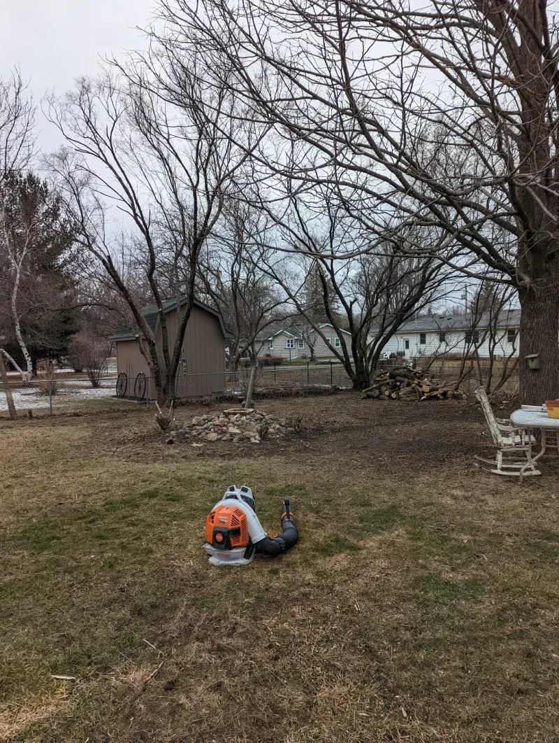 A person is sitting in the grass with a backpack.