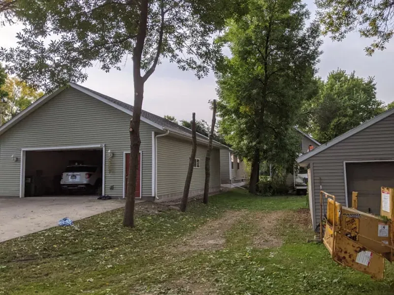 A car is parked in a garage next to a shed