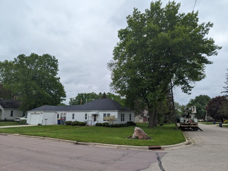 A white house sits on the corner of a residential street