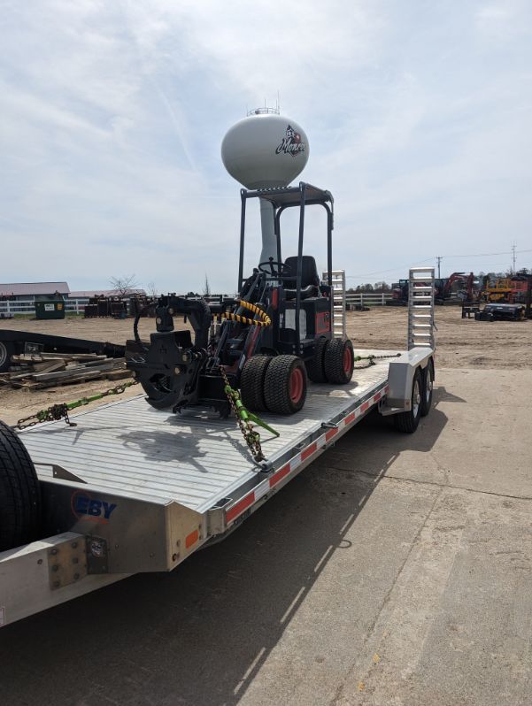 A trailer with a forklift on top of it