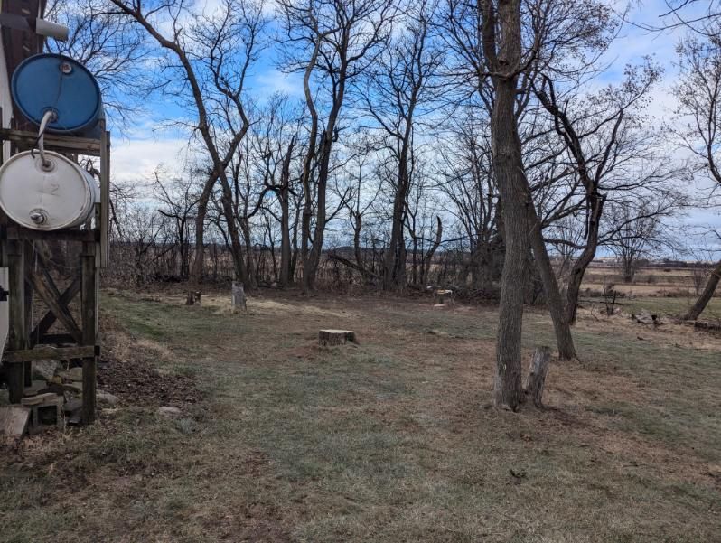 A bunch of barrels are stacked on top of each other in a field.