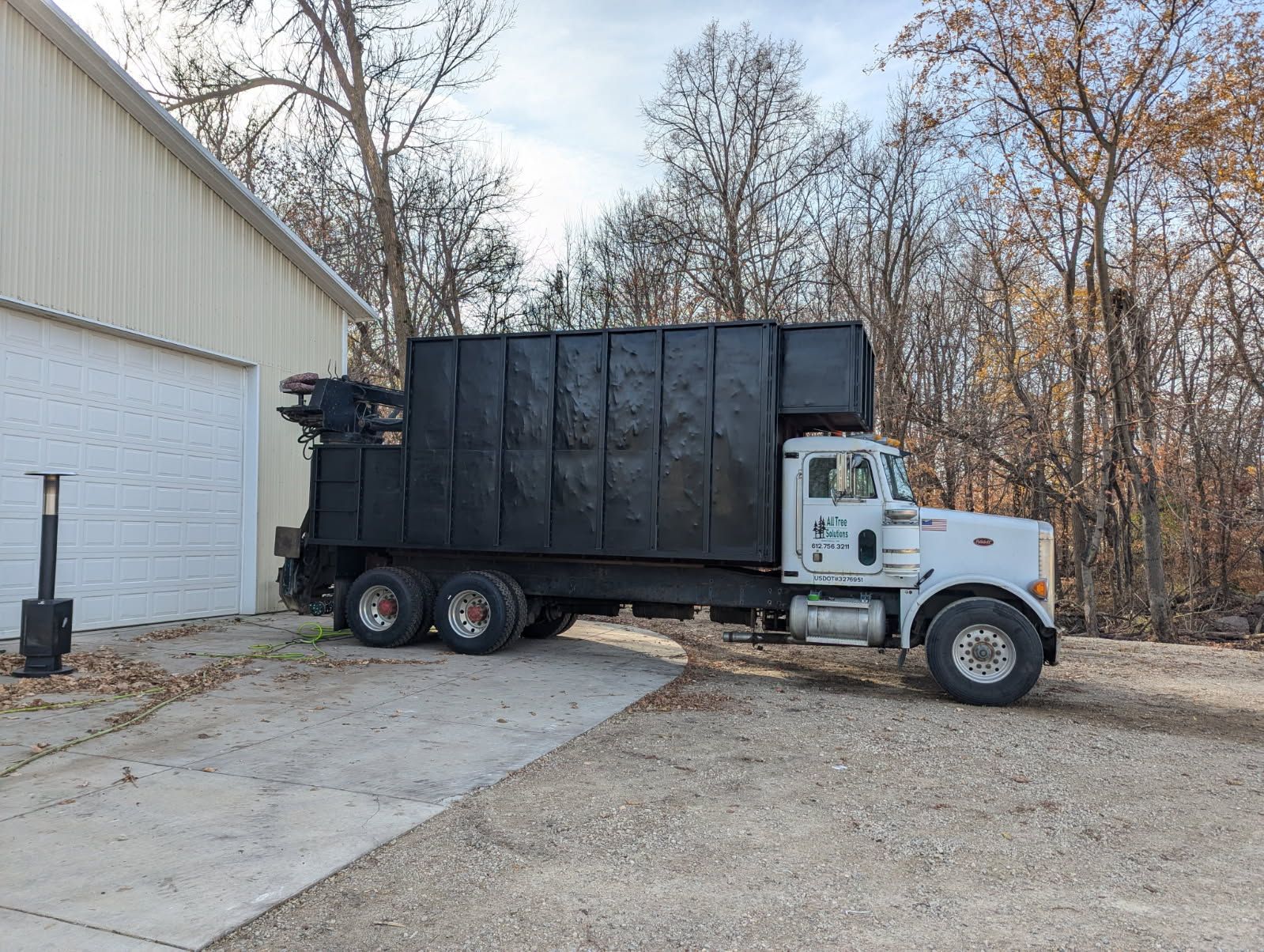 A dump truck is parked in front of a garage.