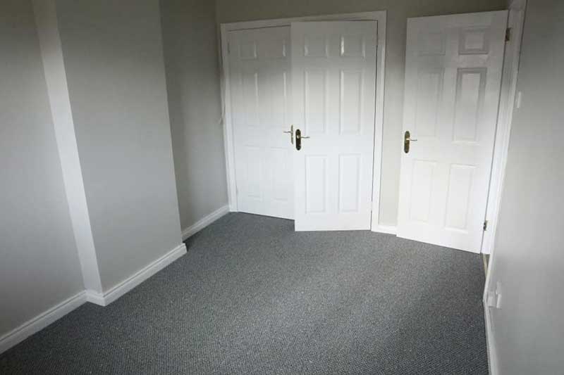 New grey-carpeted bedroom and fitted wardrobes
