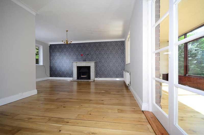 Wooden floors, contemporary grey patterned wallpapered feature wall