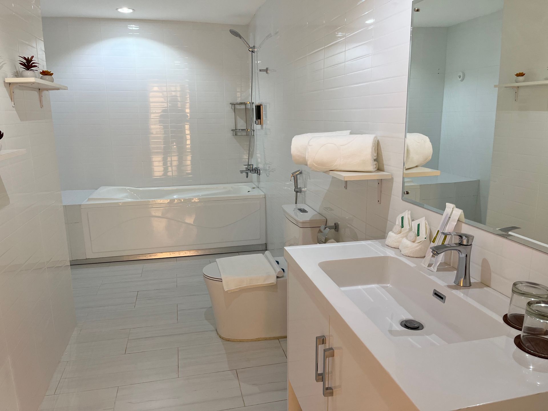 A bathroom with a sink , toilet , tub and mirror.