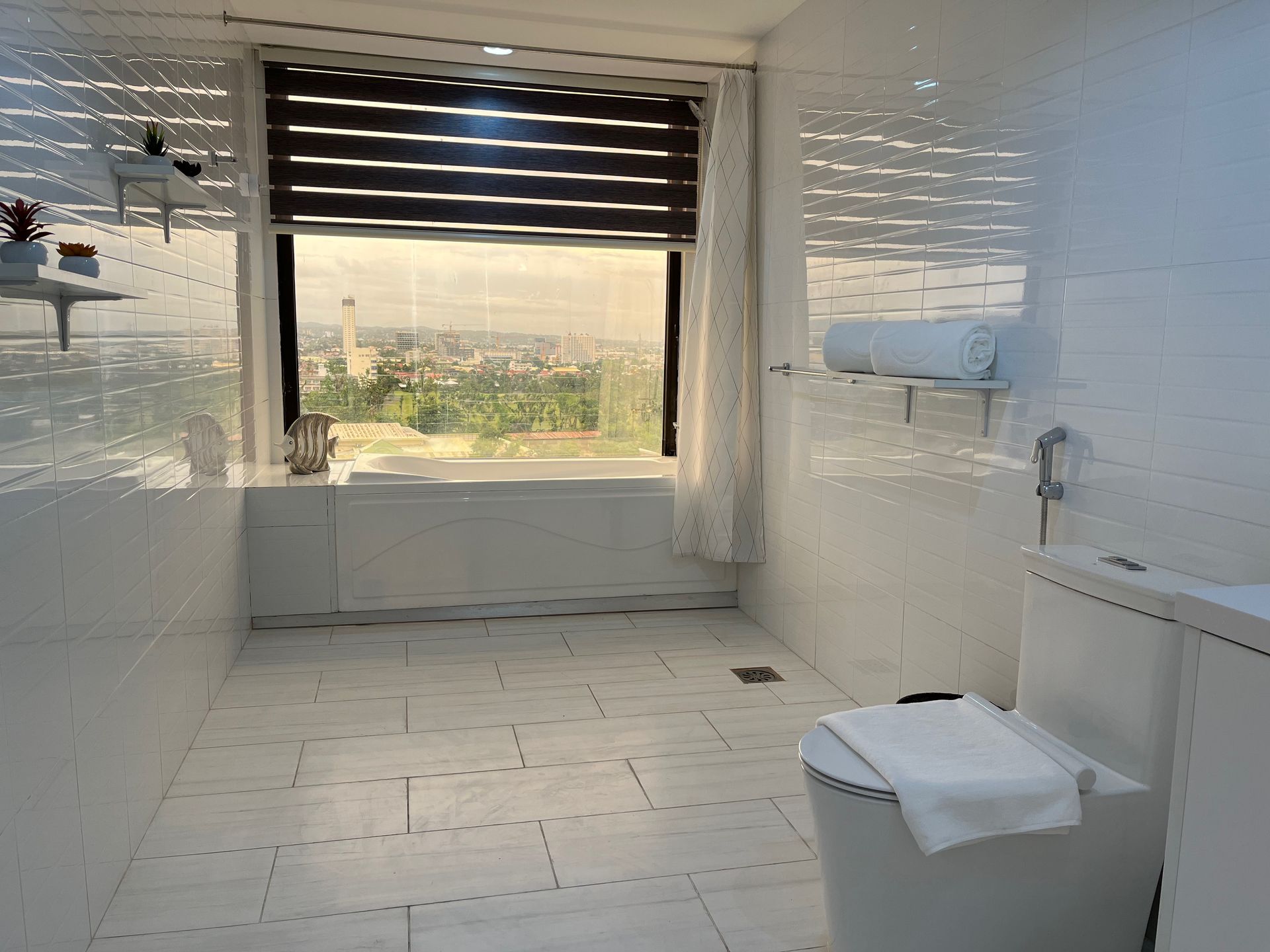 A bathroom with a toilet , sink , and window.