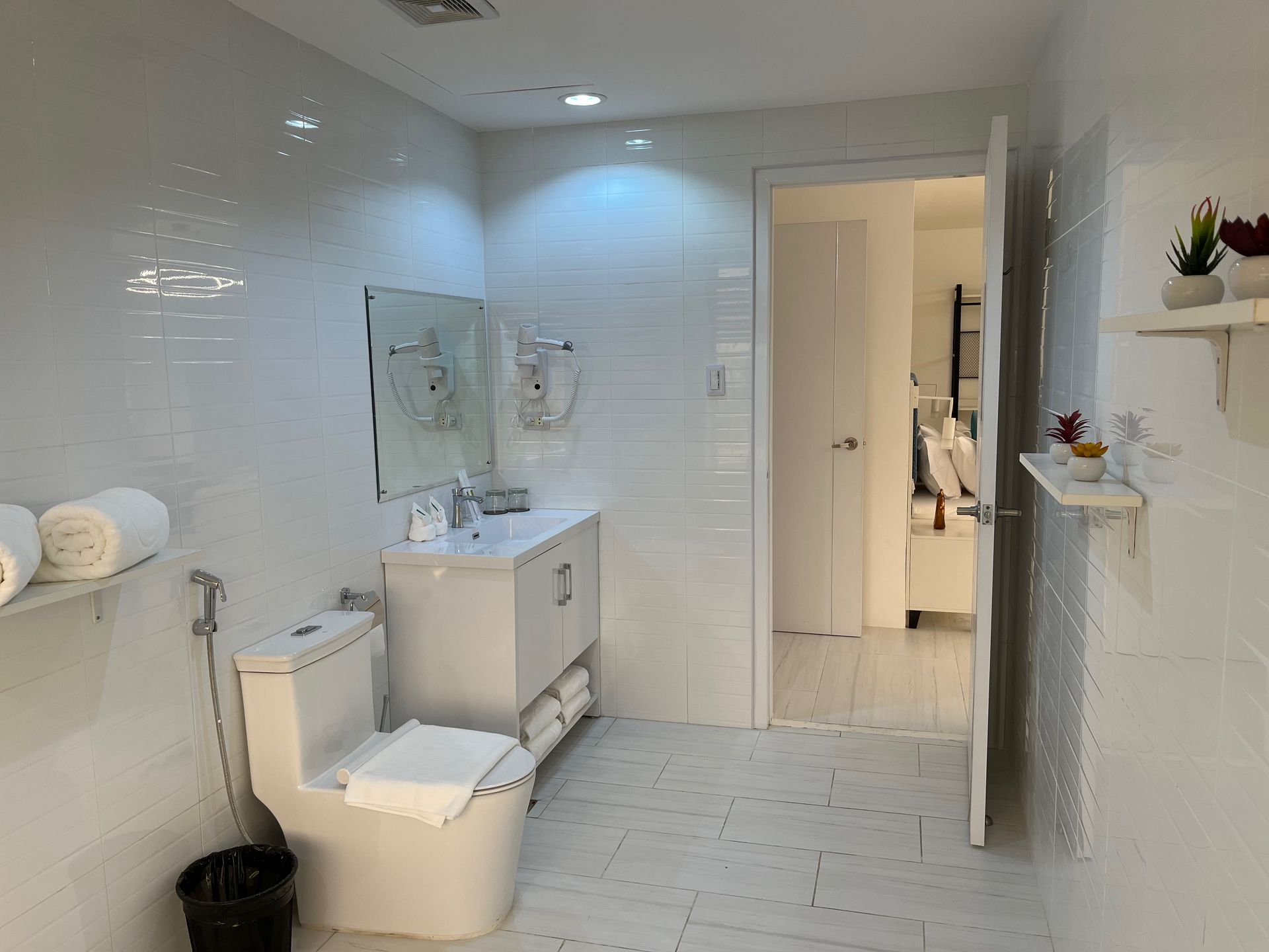 A bathroom with a toilet , sink and mirror.