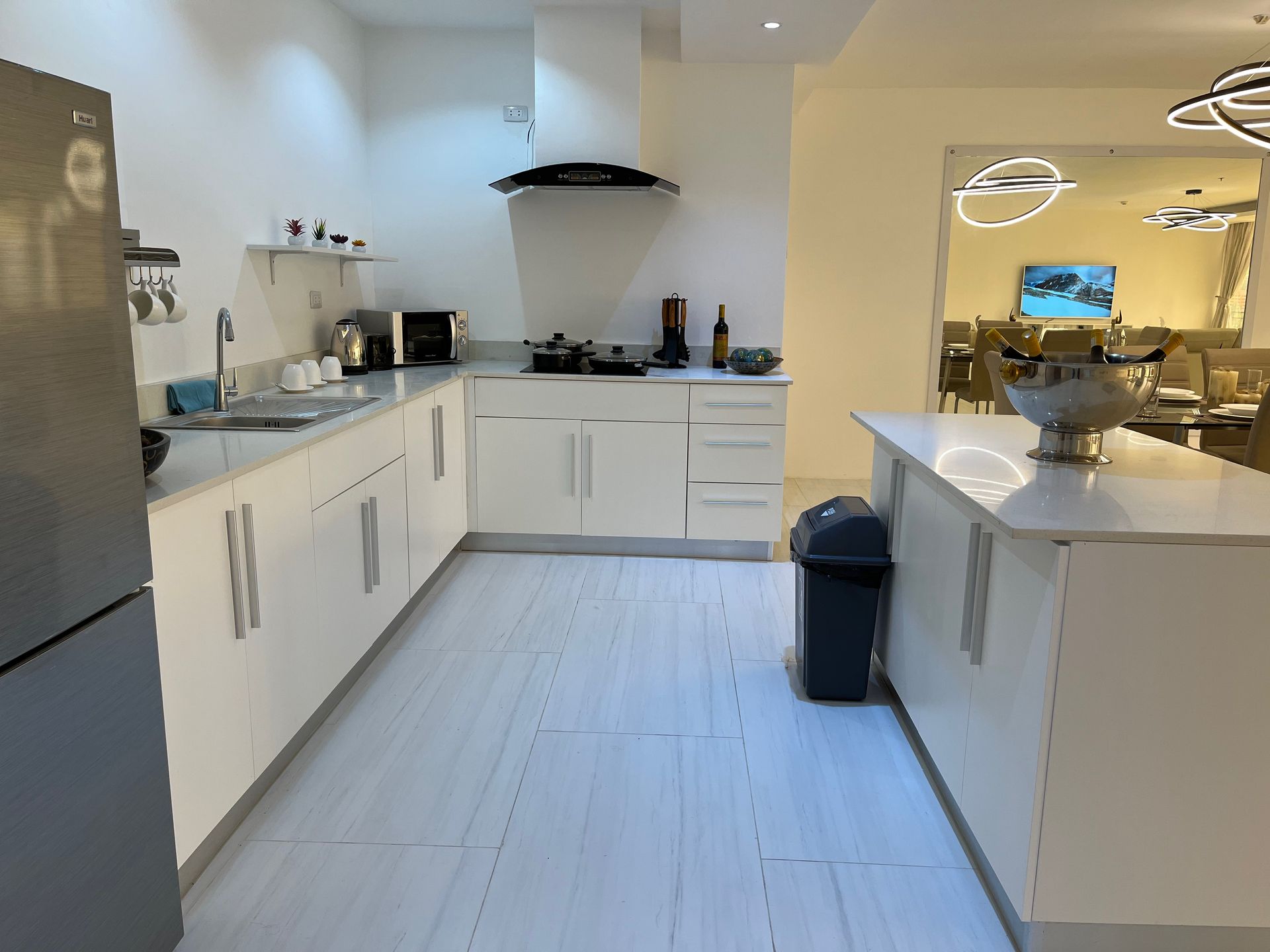 A kitchen with white cabinets and a black refrigerator