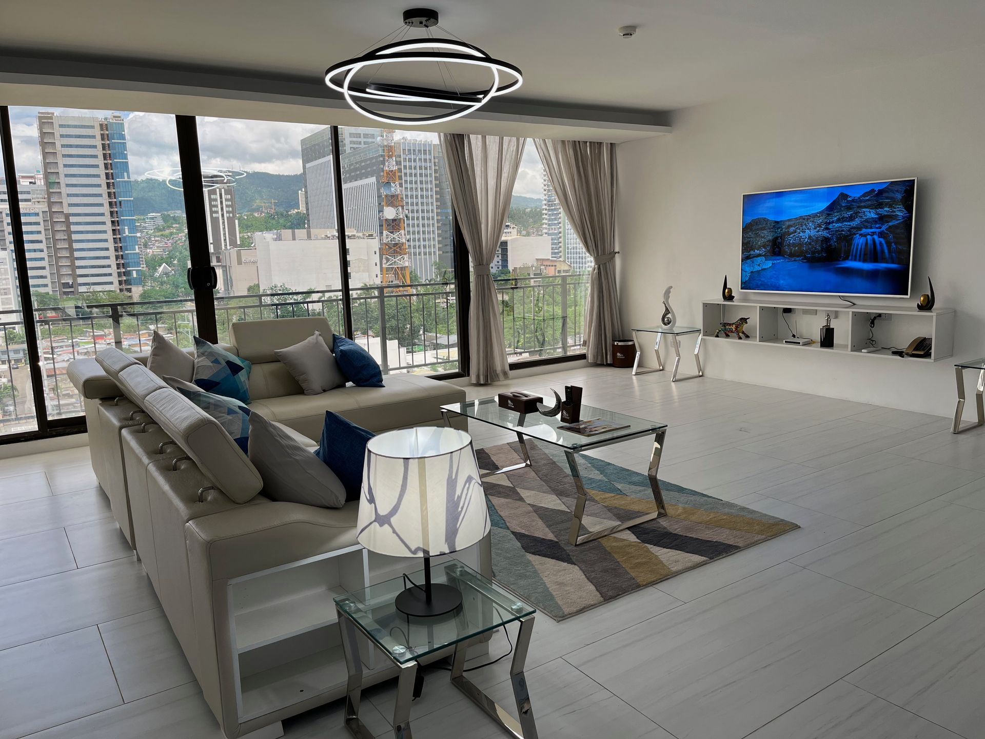 A living room with a couch , table , lamp and television.