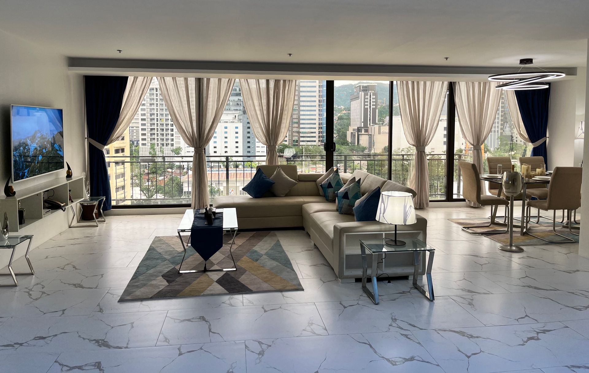 A living room with a couch , chairs , and a television.