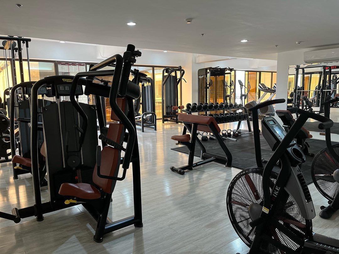 A large gym filled with lots of exercise equipment.