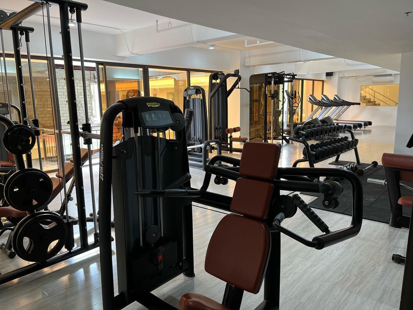 A gym filled with lots of exercise equipment and a machine.