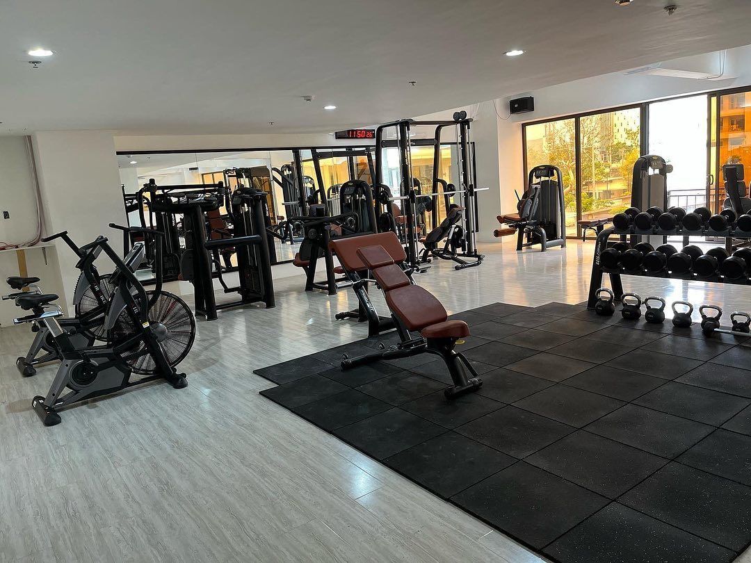 A large gym filled with lots of exercise equipment.