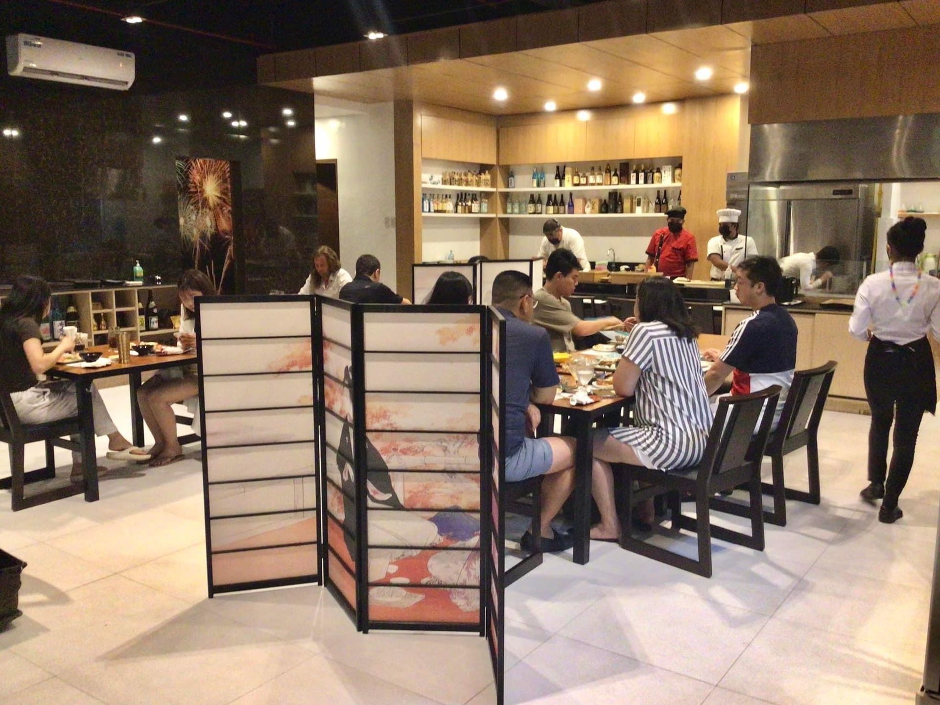 A group of people are sitting at tables in a restaurant.