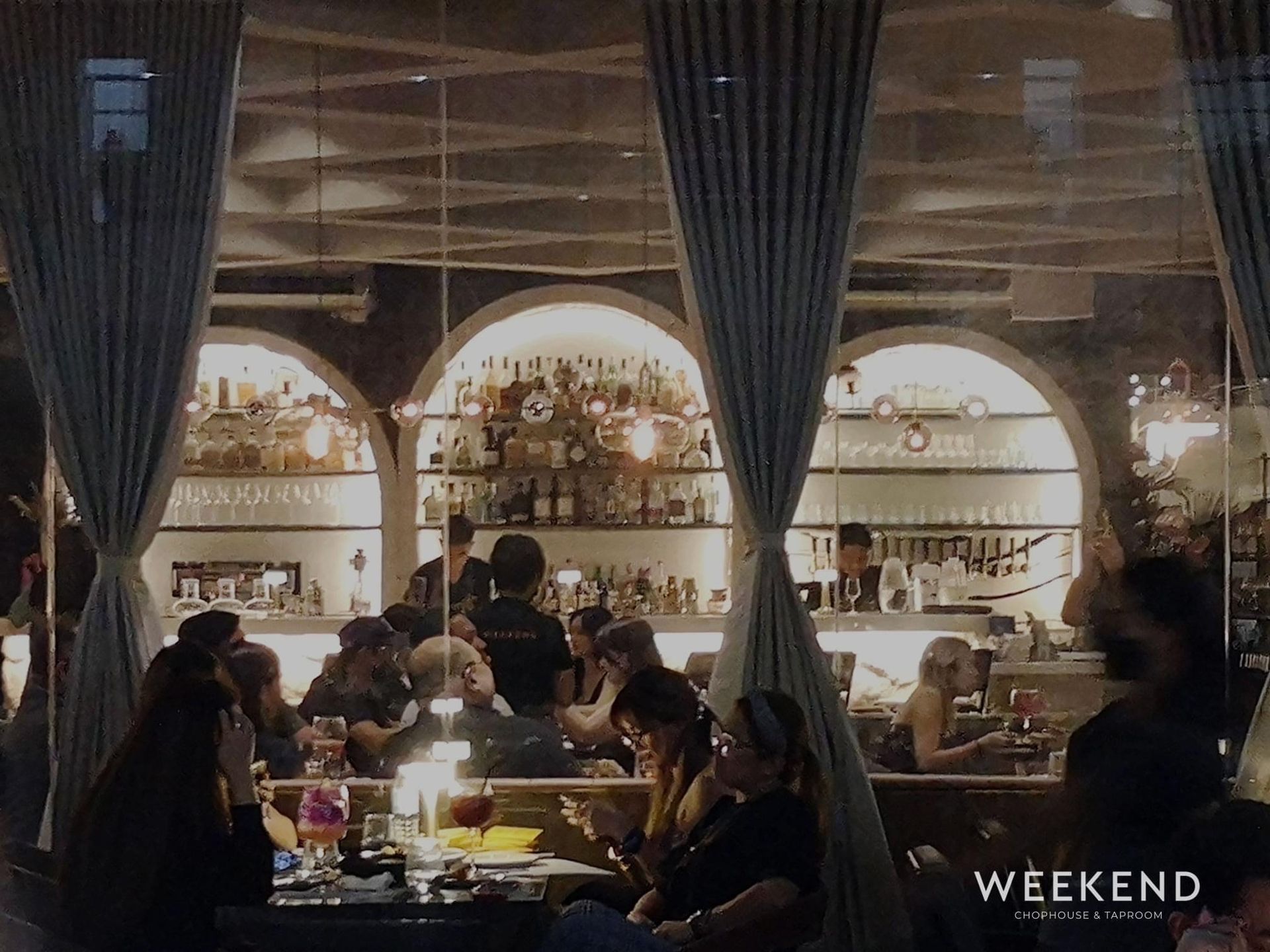 A group of people are sitting at tables in a restaurant called weekend